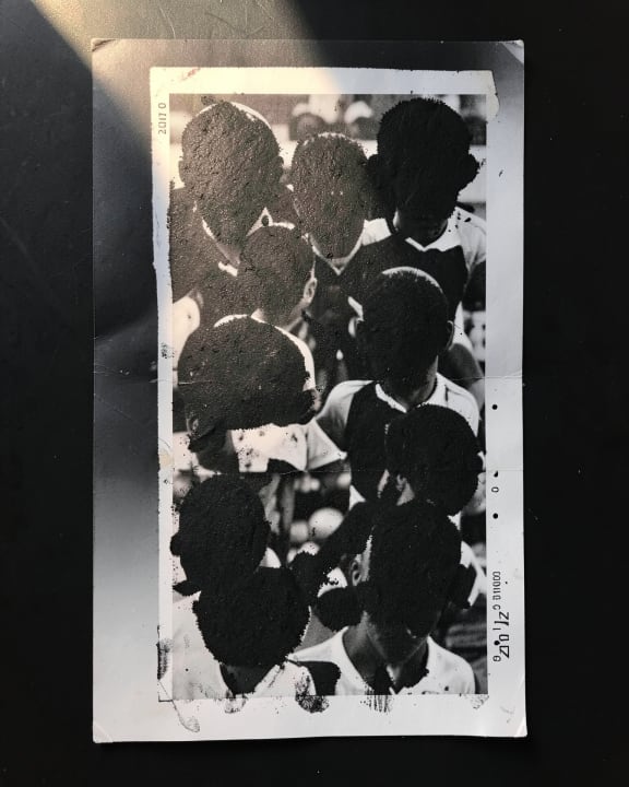 A collection of black and white portraits where the faces are covered by dark, textured patches.