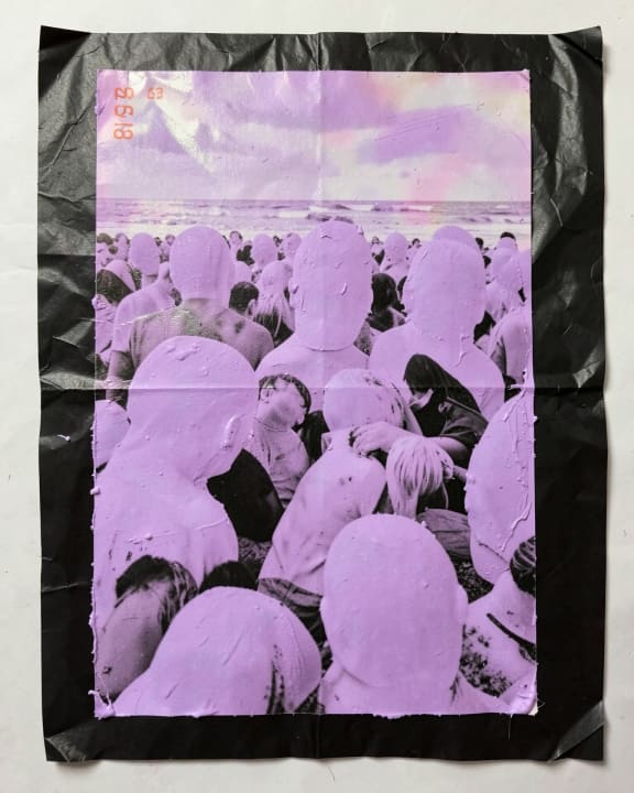 A crowd of people is gathered on a beach, but every face is covered in purple paint.